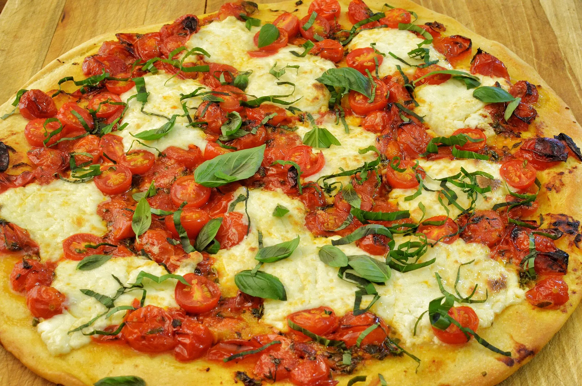 Symbolbild: Pizza Margherita mit Kirschtomaten, Mozzarella und frischem Basilikum